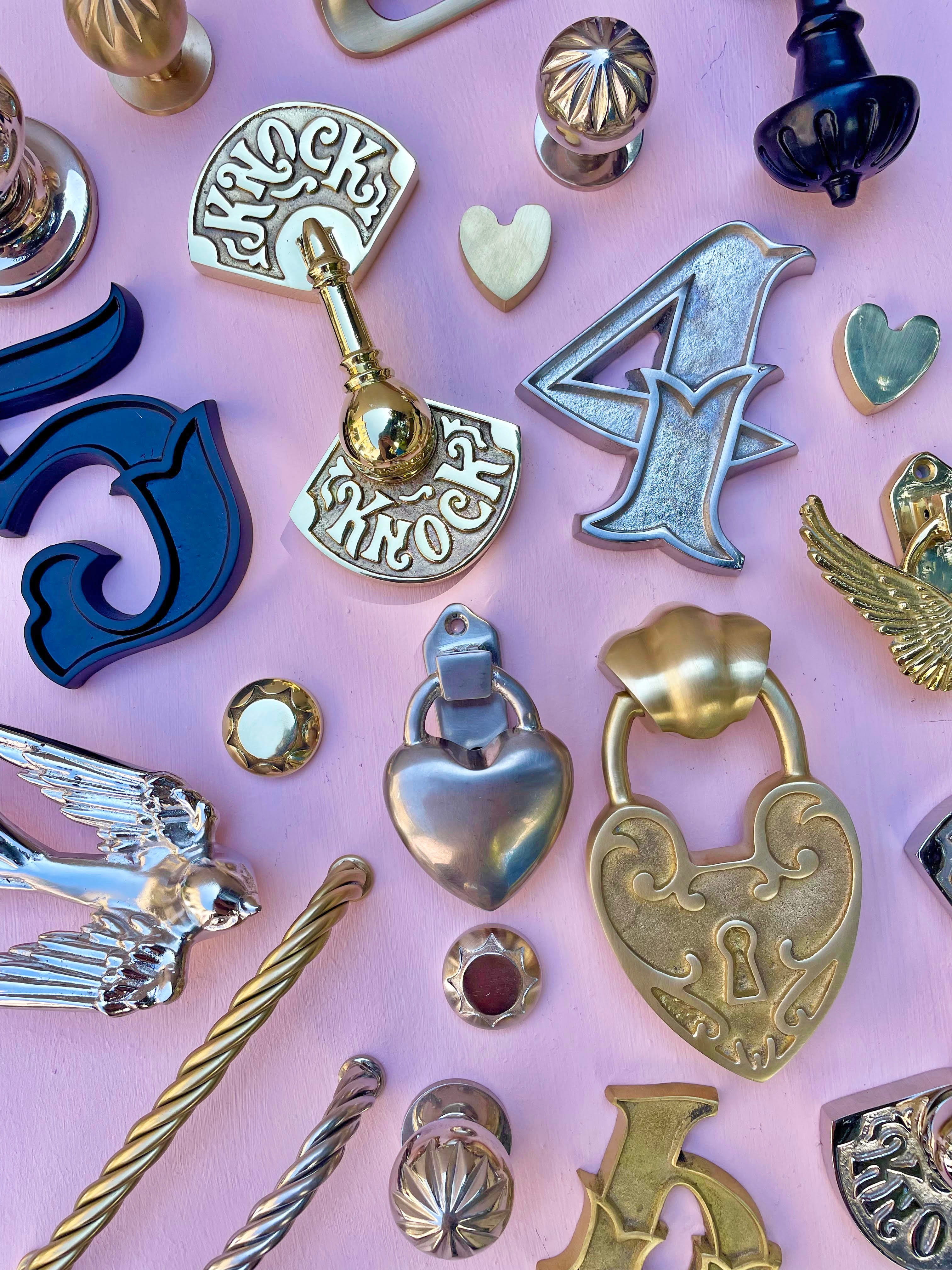 Collection of decorative door knockers on a pink background